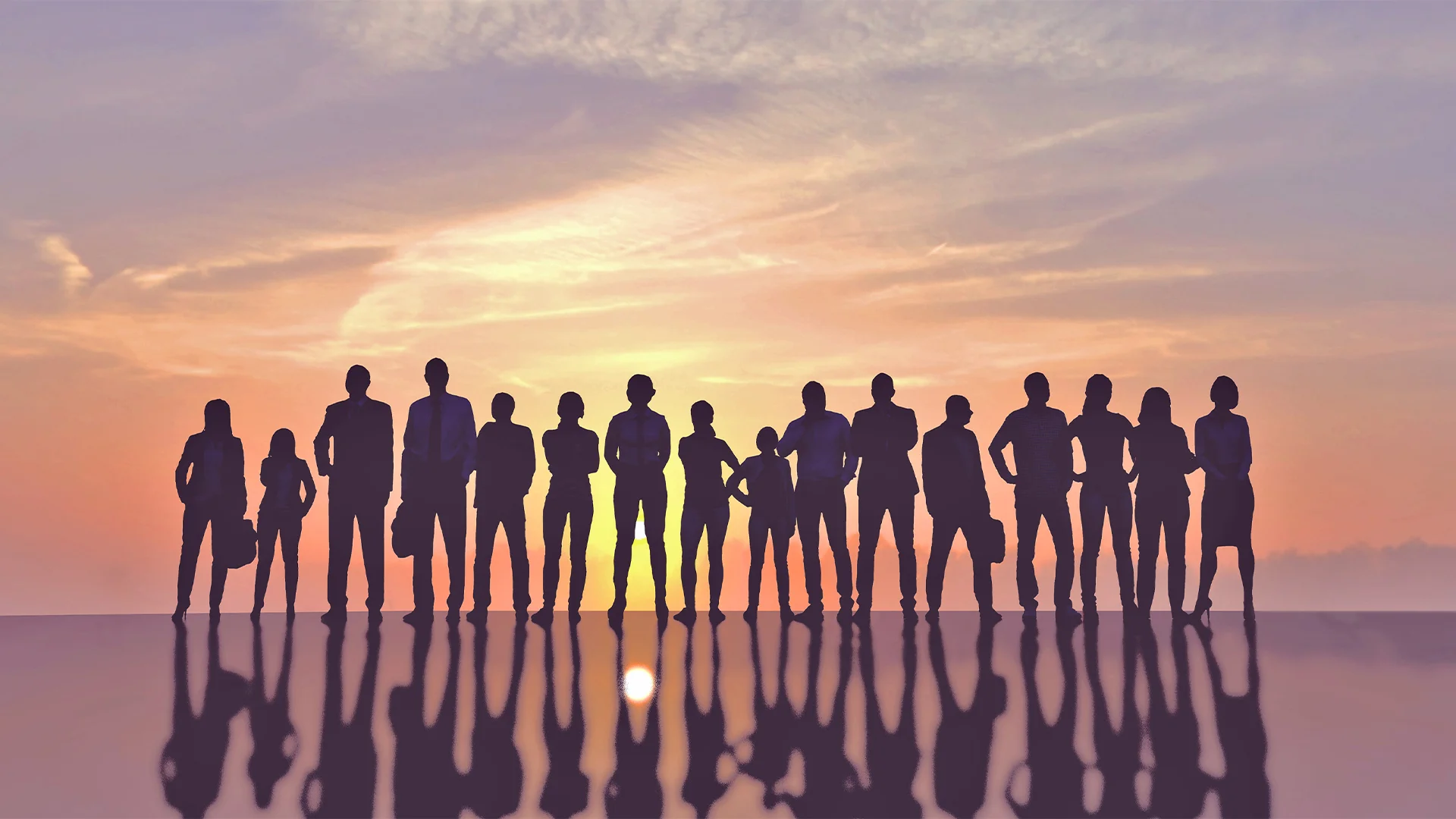 group of people standing in front of sunset